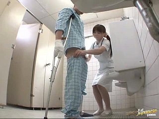 Geile Japanse verpleegster geeft een handjob aan de patiënt